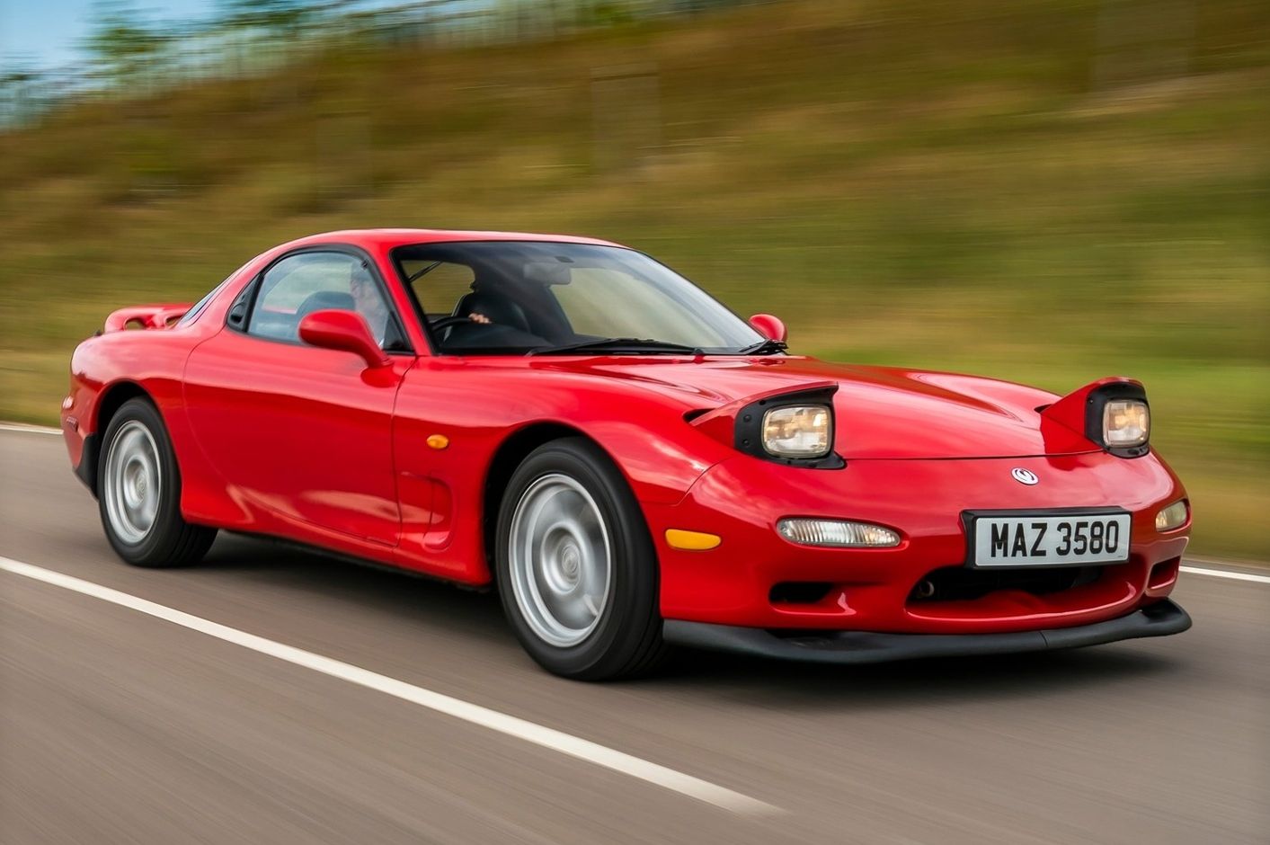 Red 1992 Mazda RX-7 driving