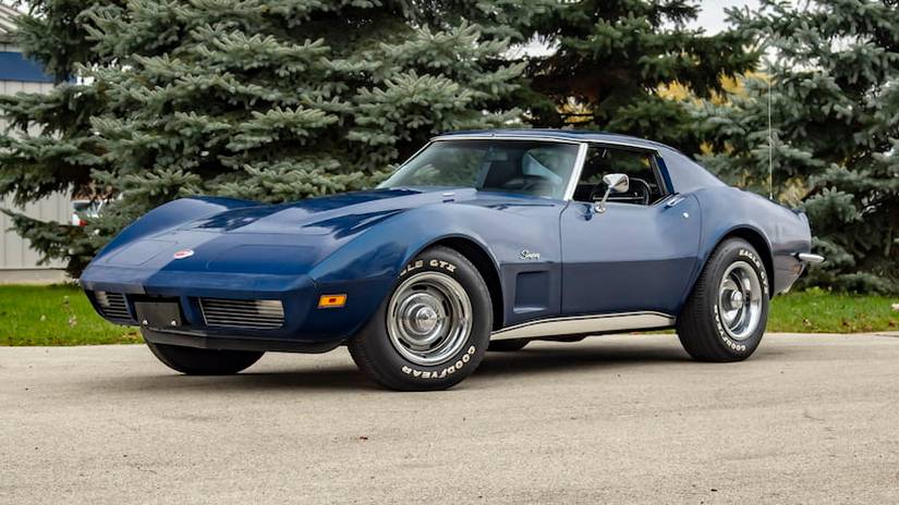 A front 3/4 shot of a blue Chevrolet Corvette C3 parked in driveway