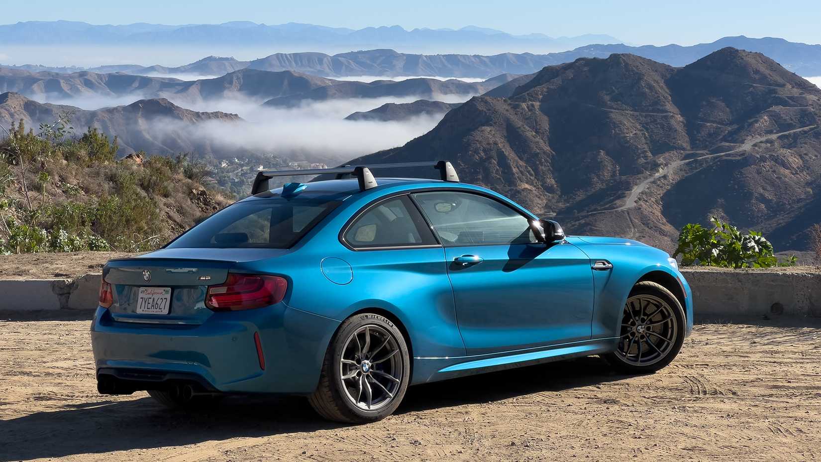 Rear 3/4 shot of a 2017 BMW M2 parked near canyon cliff 