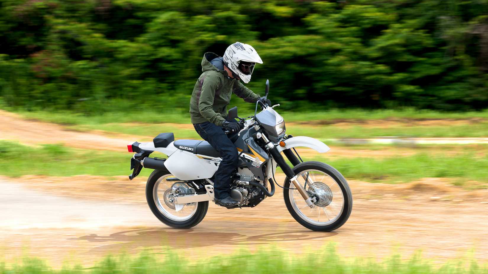 Piloto pilotando uma Suzuki DR-Z400S em uma estrada de terra