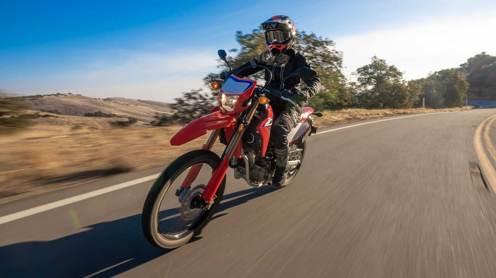 Red 2021 Honda CRF300L cruising on the road