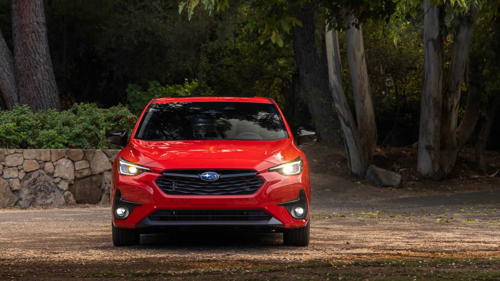 Red 2024 Subaru Impreza em uma foto frontal da floresta