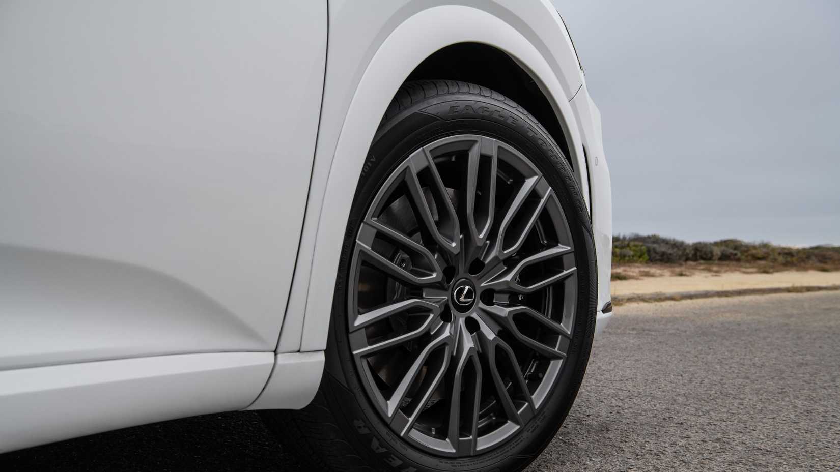 Uma foto lateral de um Lexus RX 2023 branco mostrando a roda dianteira