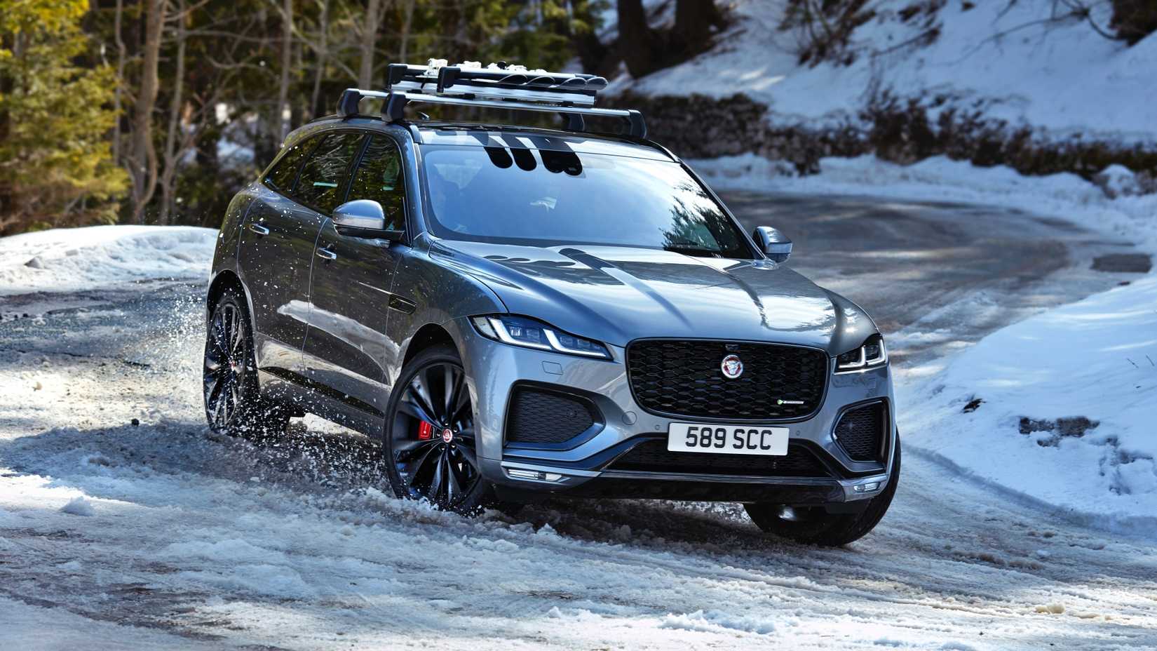A shot of a Jaguar F-Pace driving on a snowy mountain road
