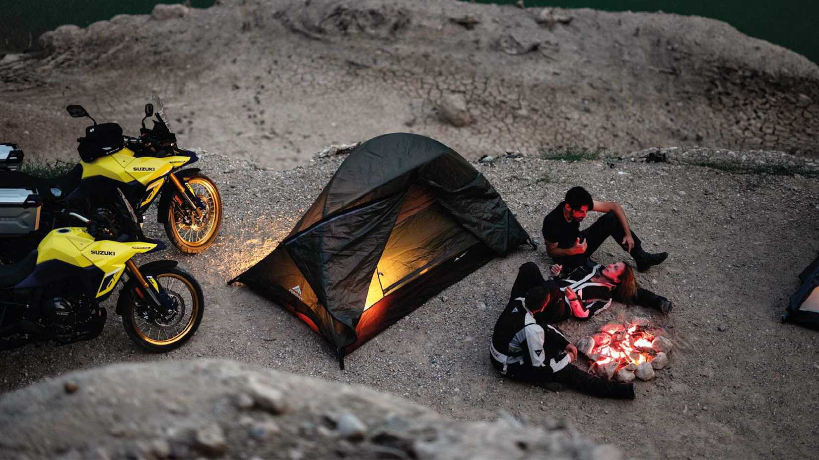 Yellow 2023 Suzuki V-Strom 800DE Adventure bikes at a campsite