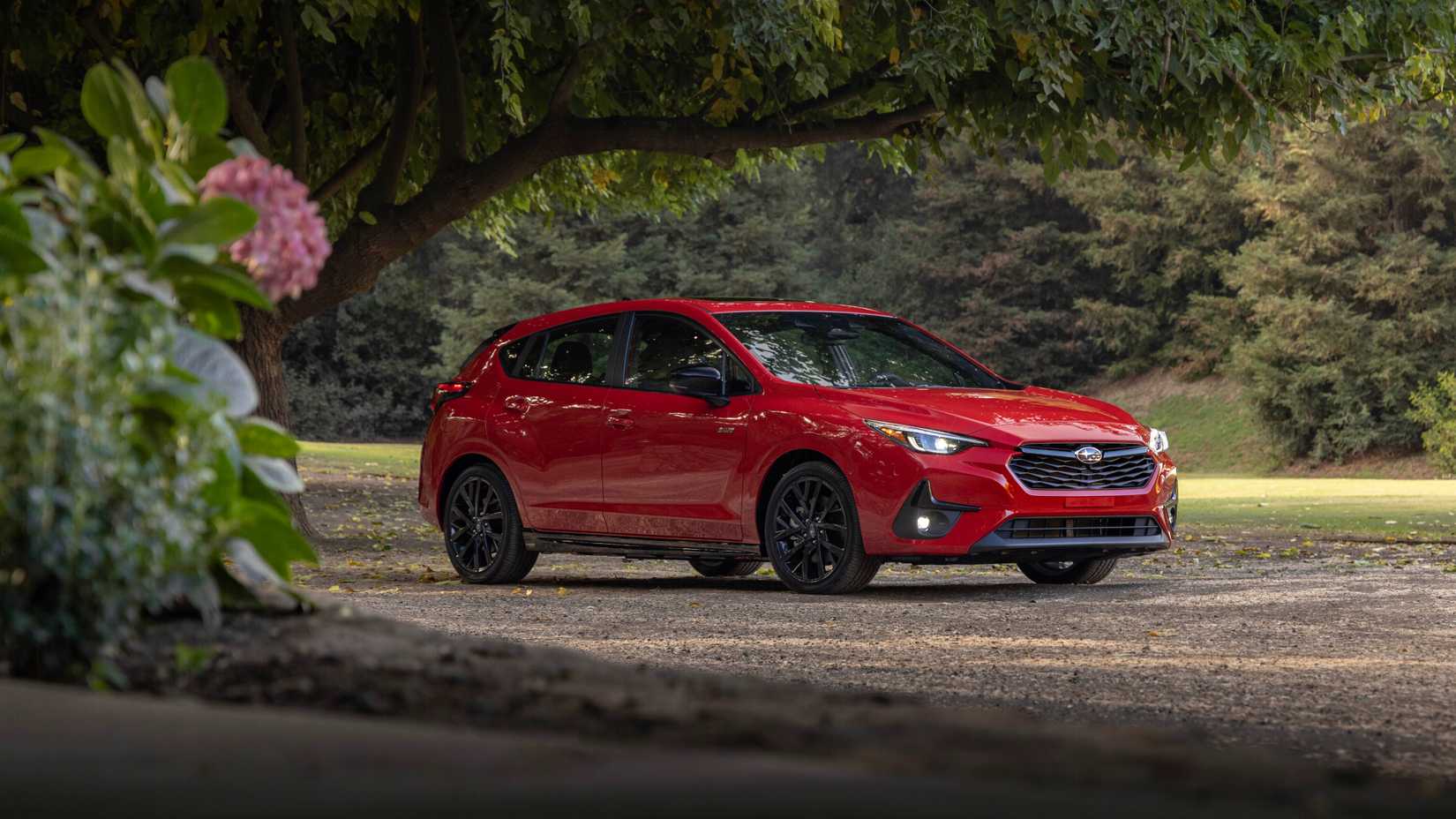 Red 2024 Subaru Impreza RS in a forest front 3/4 exterior shot