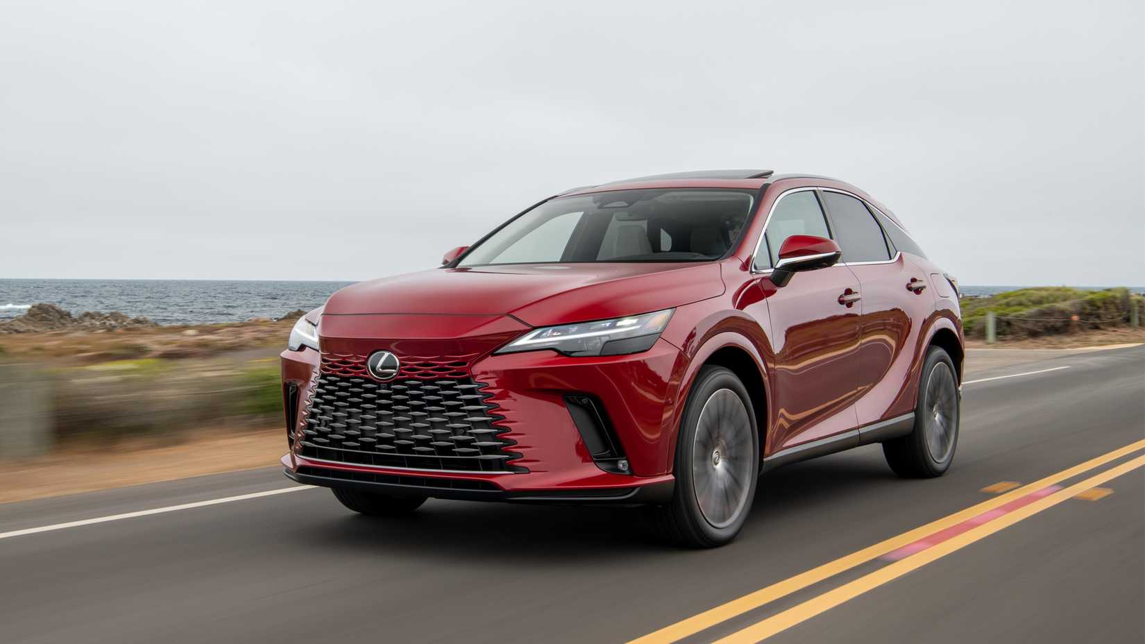 A front three-quarters shot of 2023 Lexus RX 350h cruising on a tarmac road