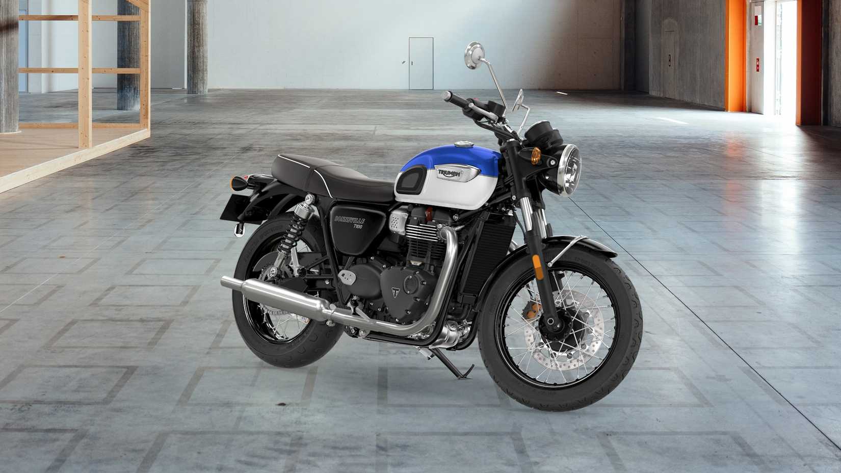 Blue 2021 Triumph Bonneville T100 estacionada em um armazém