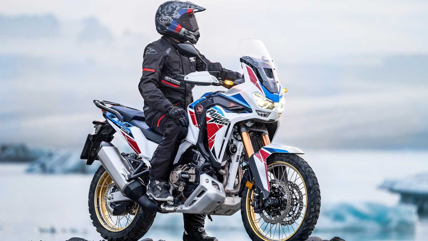 Uma foto lateral 3/4 de um piloto sentado em uma Honda Africa Twin 2022