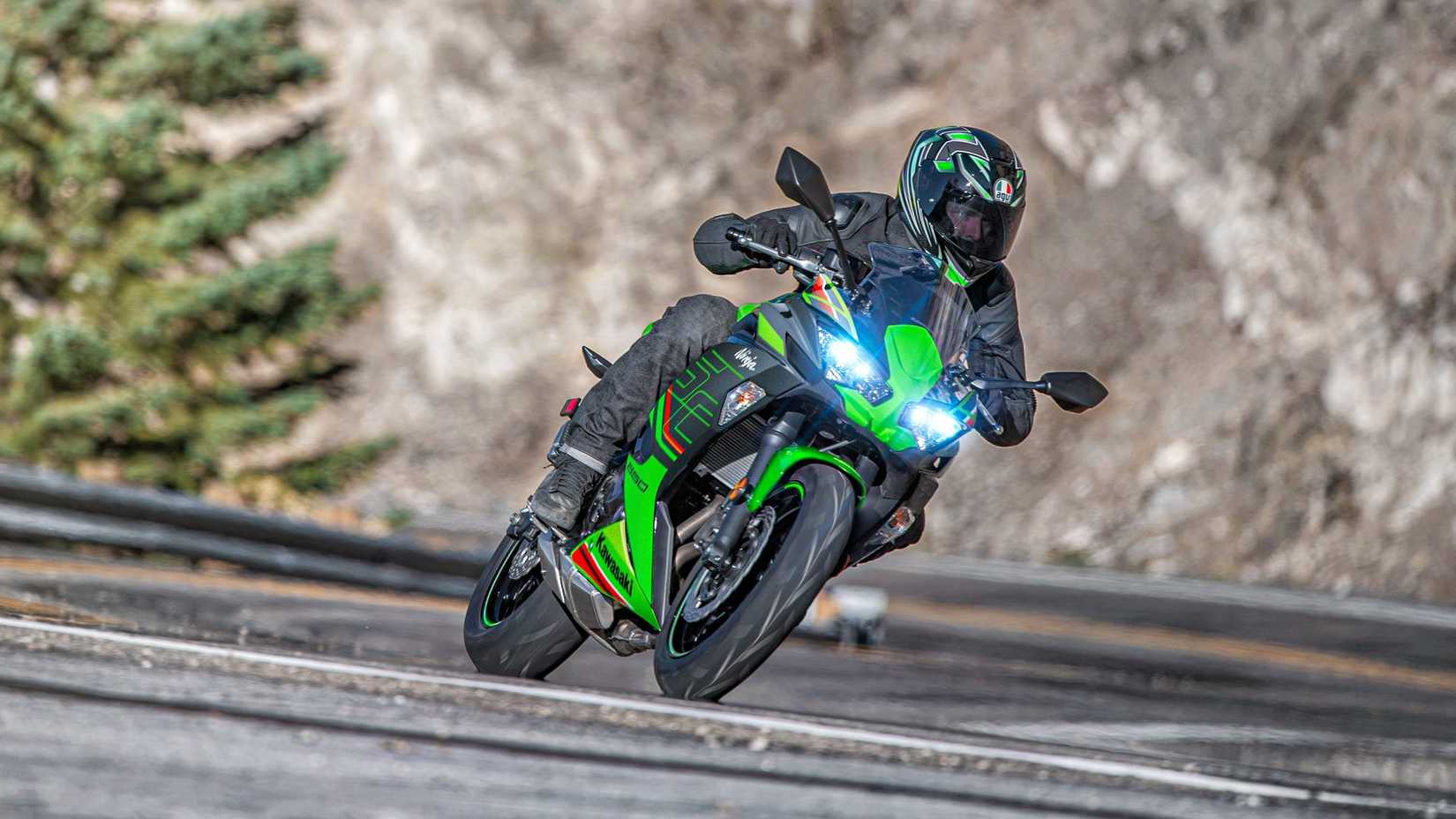 Green 2023 Kawasaki Ninja 650 KRT Edition on a twisty road