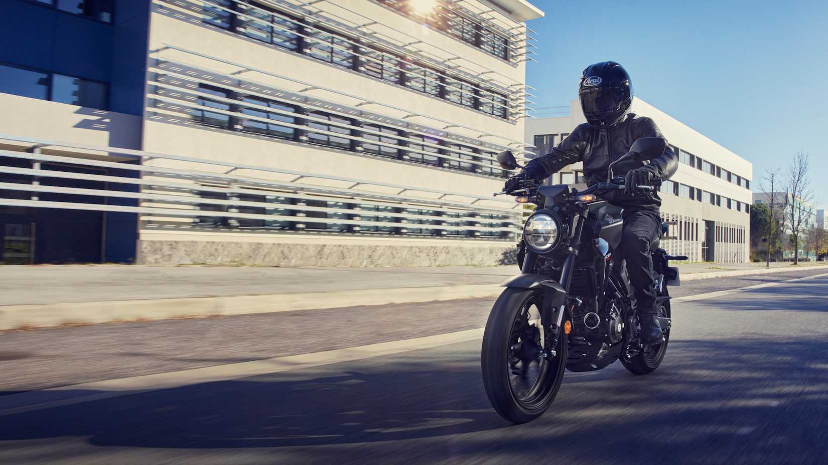 Honda CB300R preta 2022 passando por um prédio