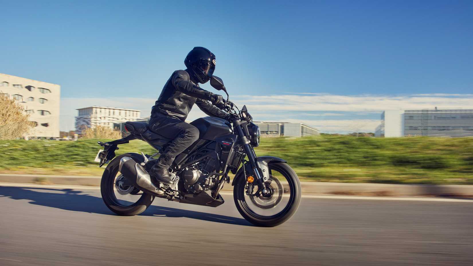 Black 2022 Honda CB300R cruising up a road