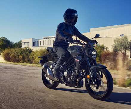 Honda CB300R preta cruzando uma estrada