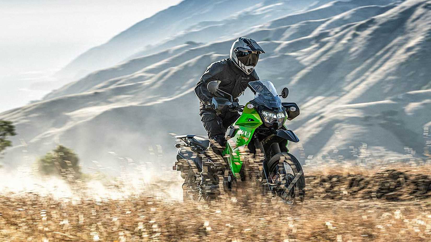 Green 2023 Kawasaki KLR650 S tearing up a trail