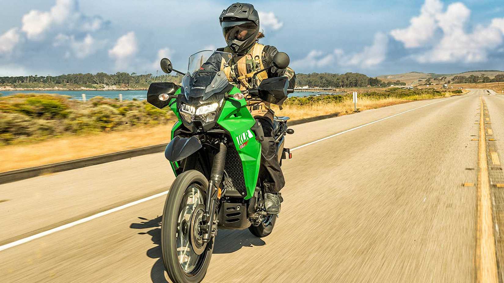 Verde 2023 Kawasaki KLR650 S cruzando na estrada
