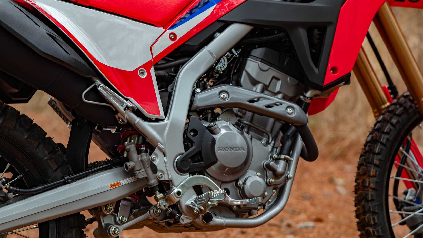 Detalhe de close-up do motor Honda CRF300L vermelho 2023