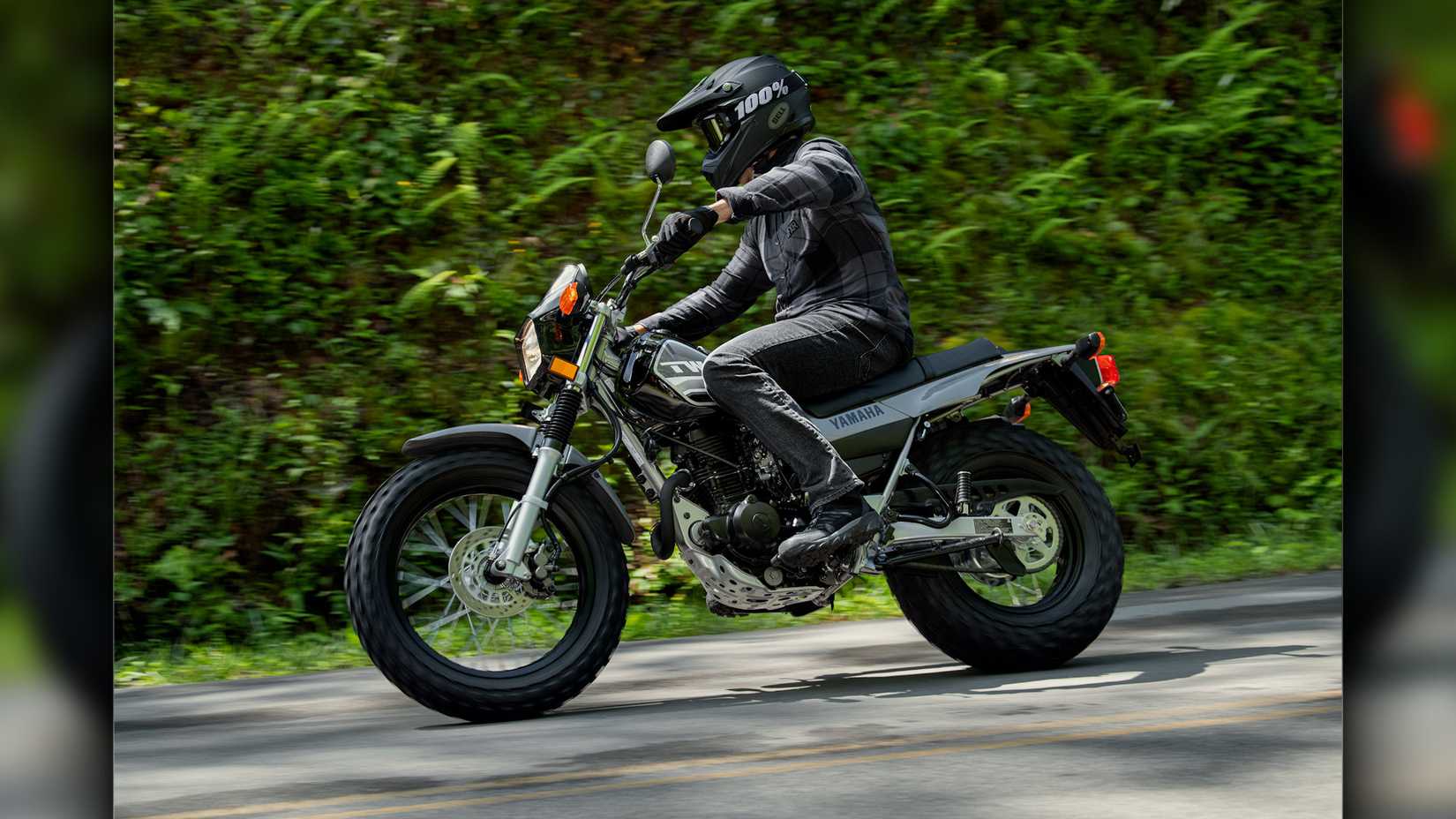 Gray 2023 Yamaha TW200 cruising on the road