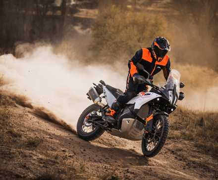 Uma cena de ação de uma KTM 790 ADVENTURE 2023 descendo uma colina