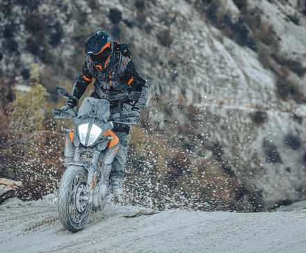 Orange 2023 KTM 390 Adventure rasgando uma trilha de neve