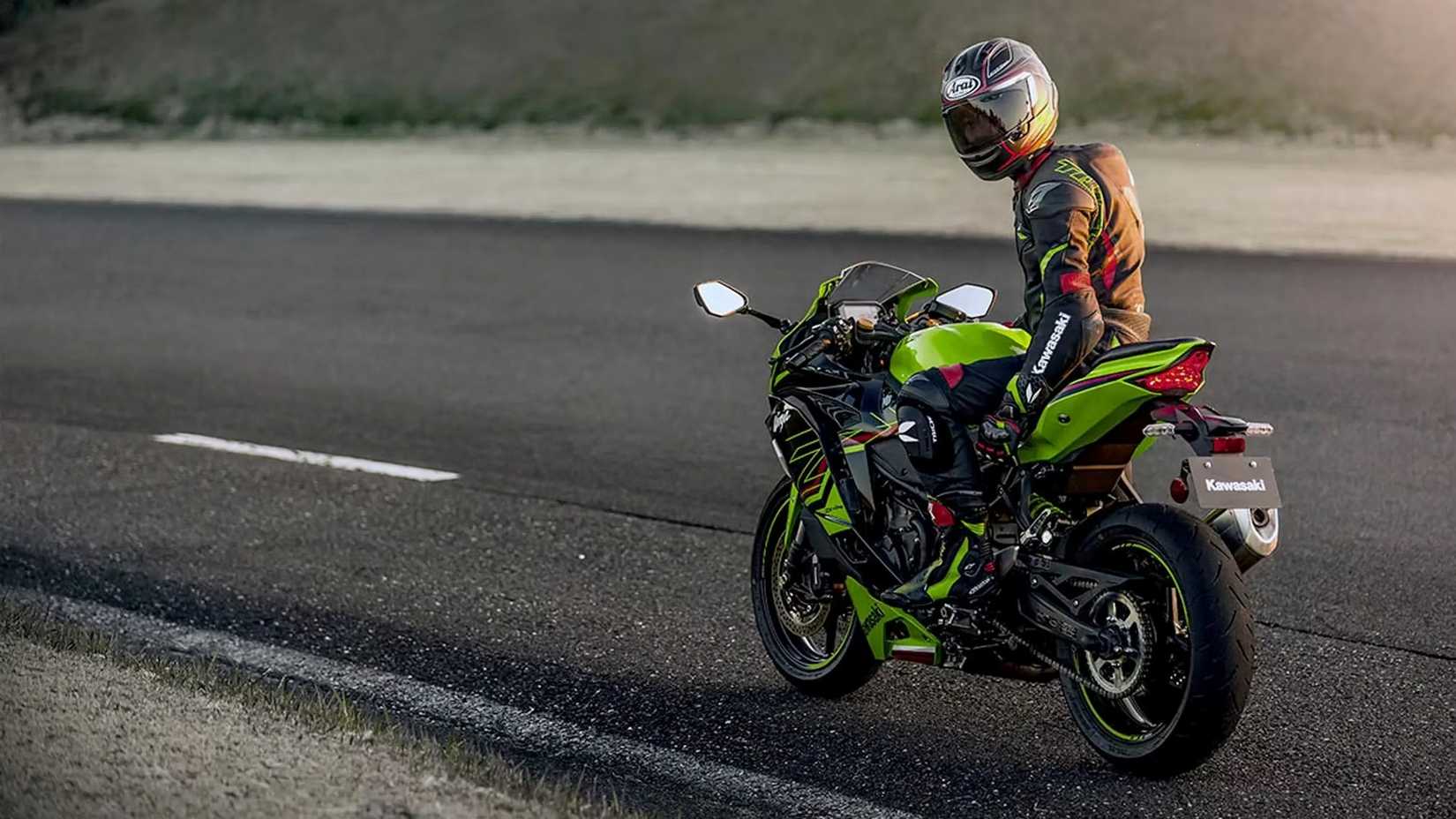 A rider astride a green 2023 Kawasaki Ninja ZX-4RR KRT