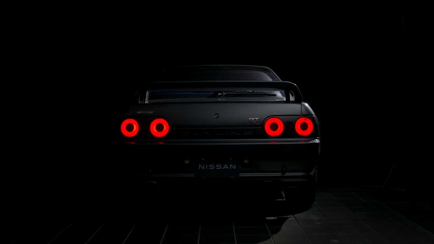 Rear view of a grey 1989 Nissan Skyline R32 GT-R in the dark
