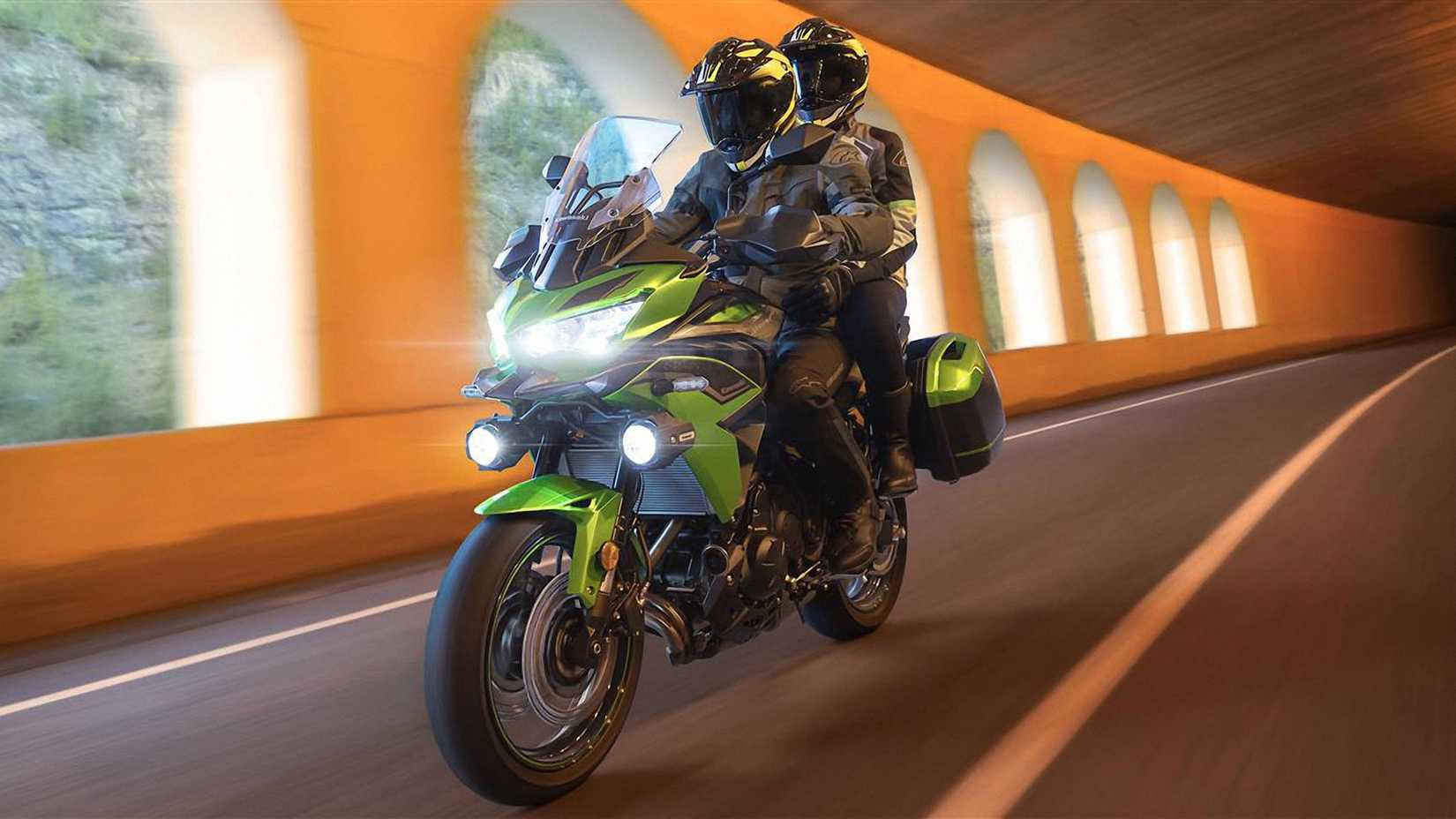 Accessorized green 2022 Kawasaki Versys 650 cruising through a tunnel