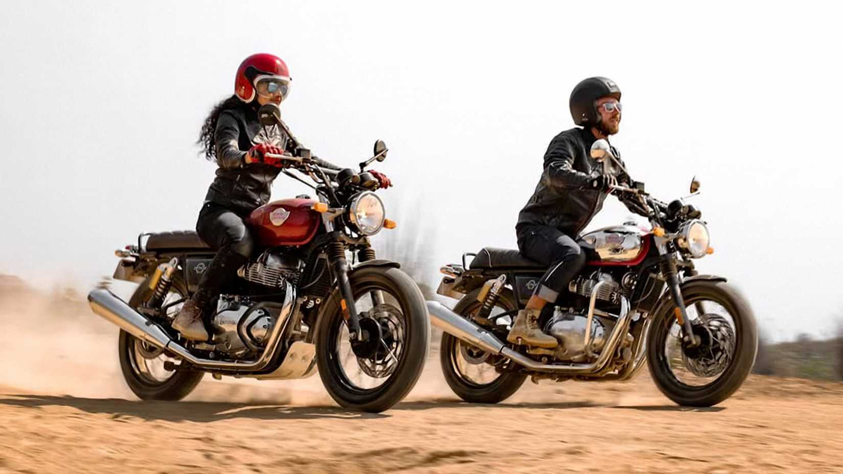 A pair of 2023 Royal Enfield INT650 motorcycles cruising over sandy terrain
