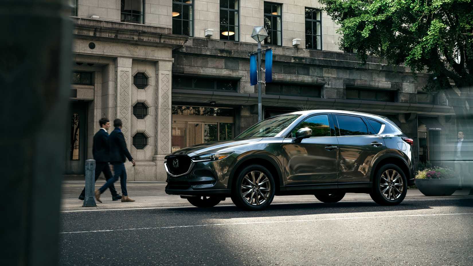 Front 3/4 action shot of 2023 Mazda CX-5 driving on road