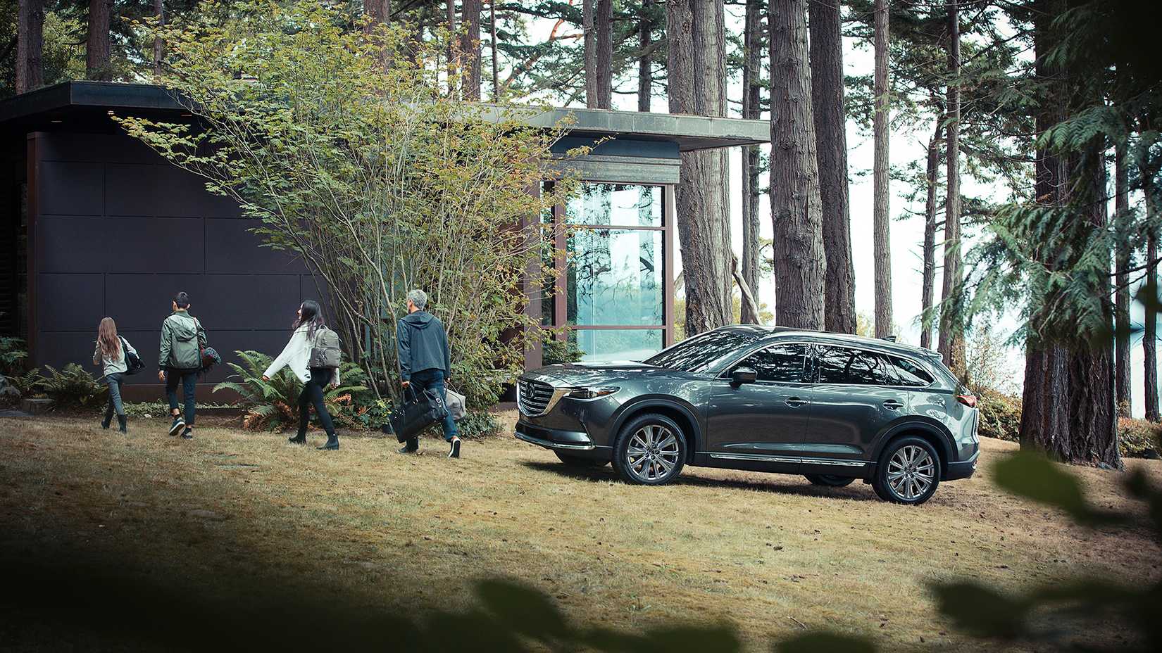 A 2023 Mazda CX-9 Signature with a family in the forest
