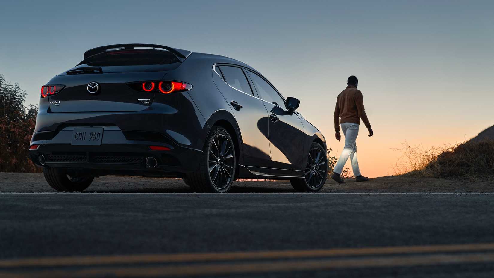 A rear 3/4 shot of a 2023 Mazda 3 Turbo parked on the road