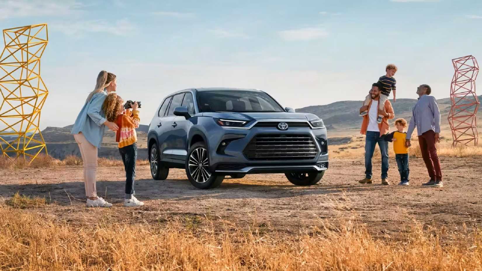 Vista frontal de uma família em torno de um Toyota Grand Highlander 2024