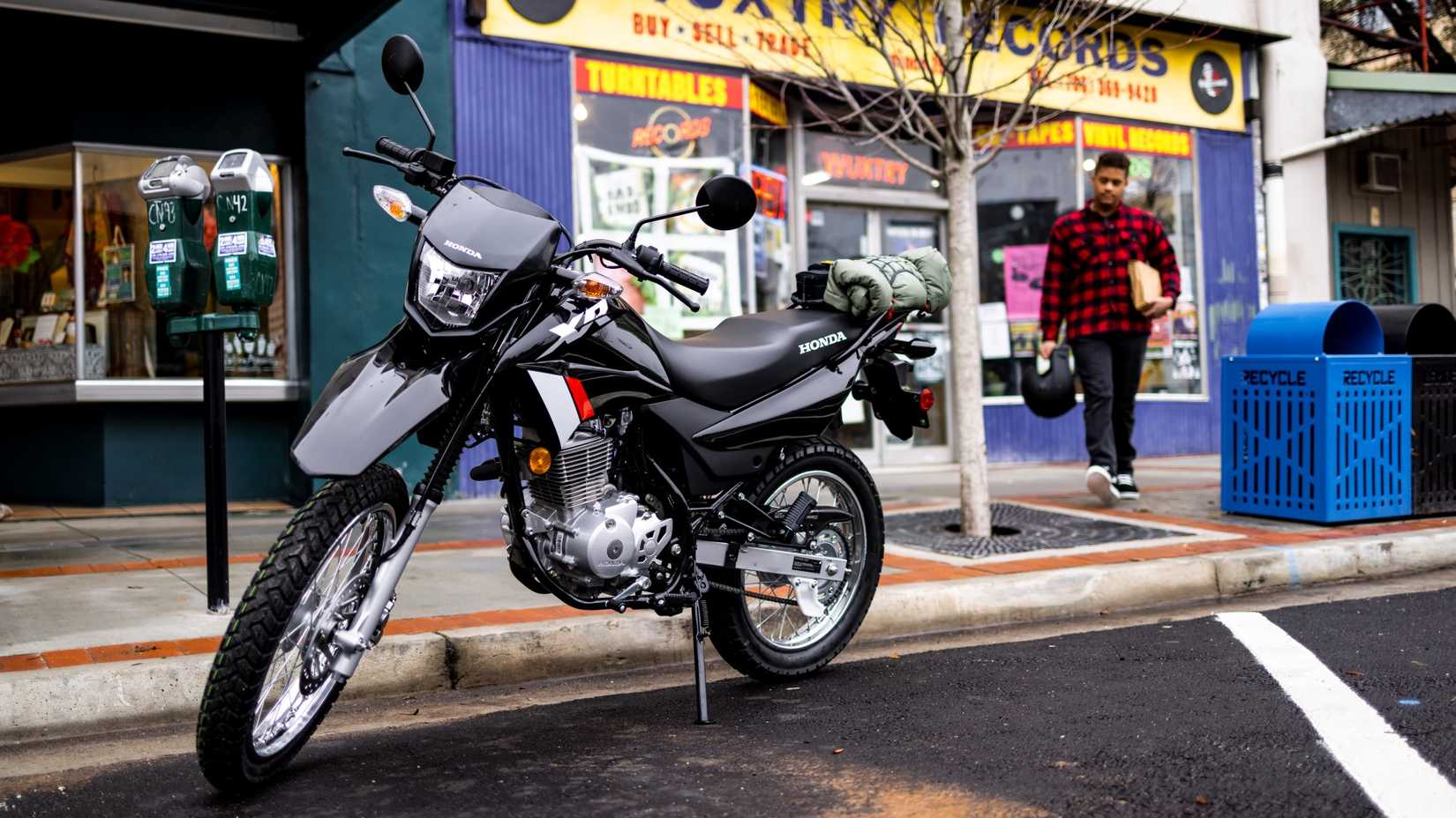 Uma foto frontal 3/4 de uma Honda XR150L estacionada na rua