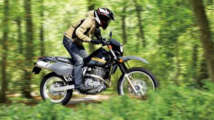 Suzuki DR650S preto navegando em uma trilha