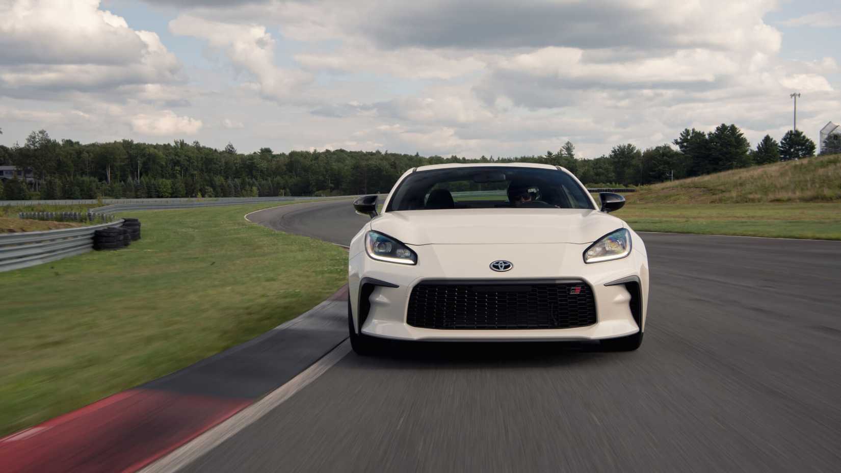 Front action shot of a white 2023 Toyota GR86 at the track