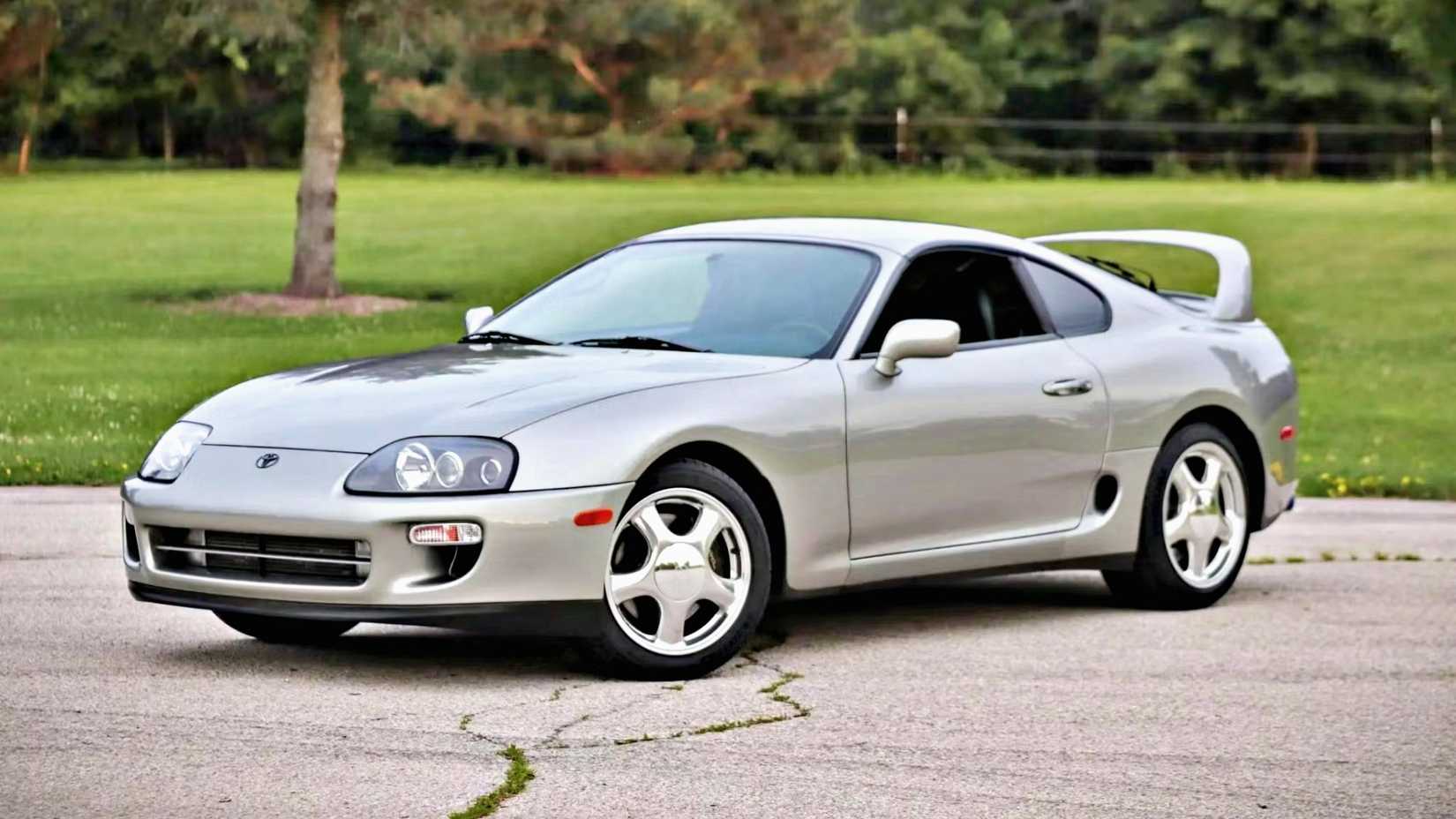 Prata Mk4 Toyota Supra em prata posando no estacionamento