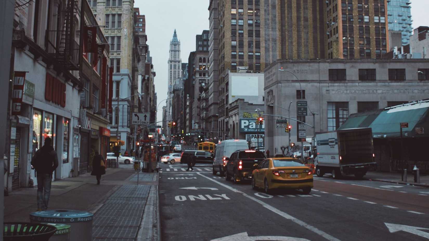 A rear shot of vehicles yielding to a pedestrian at an intersection