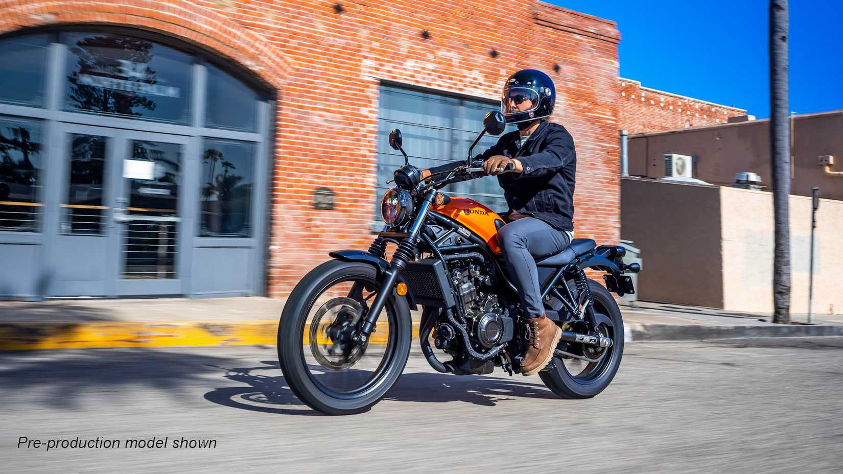 Orange 2023 Honda SCL500 cruzando a cidade