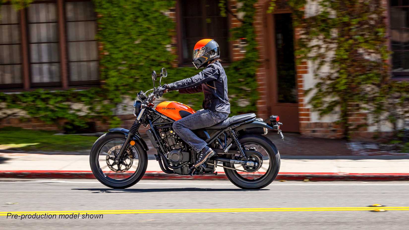Orange 2023 Honda SCL500 cruising through town