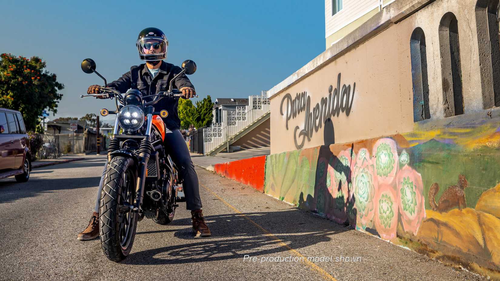 Piloto sentado em um SCL500 2023 laranja