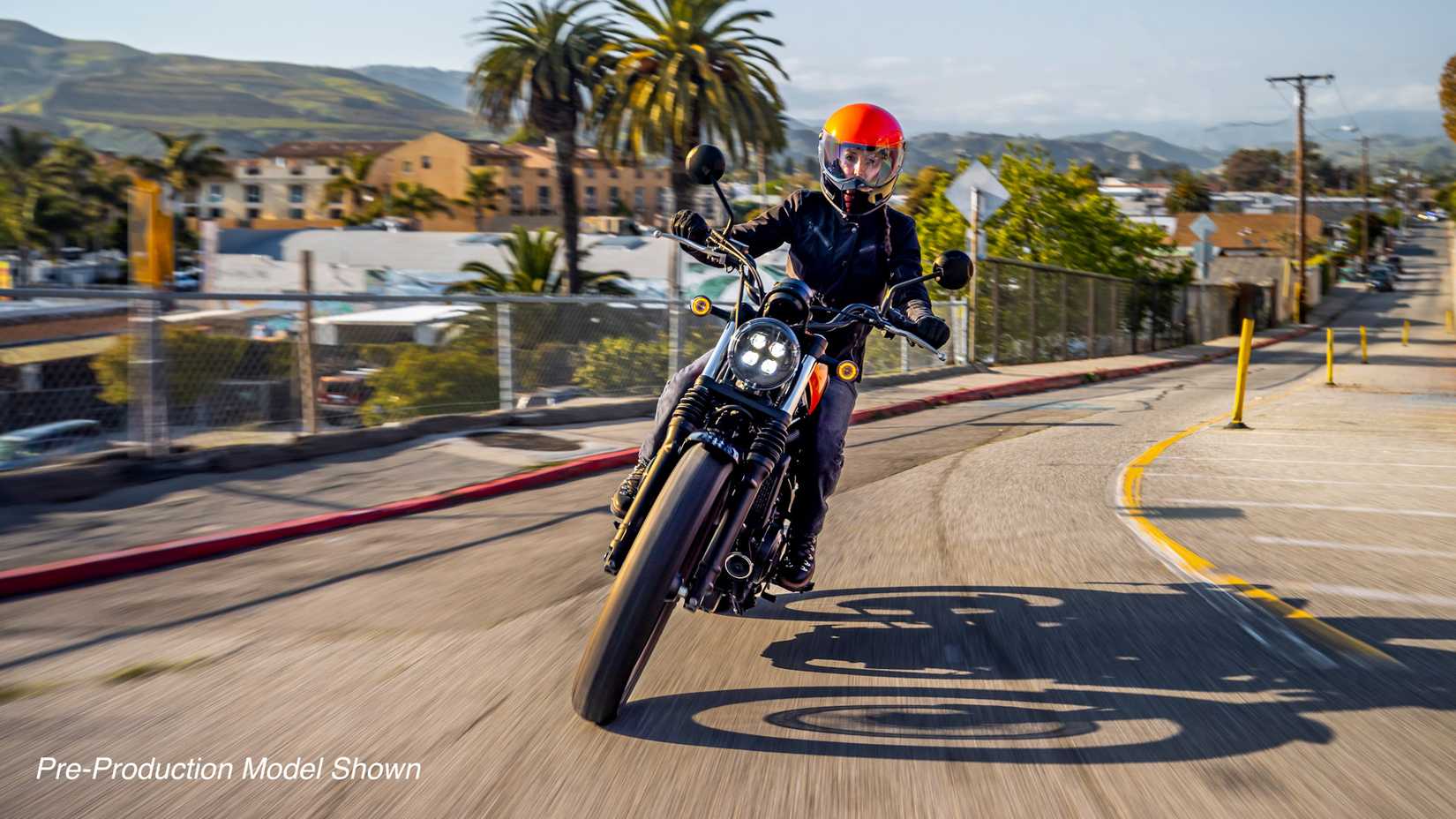 Orange 2023 Honda SCL500 coming out of a curve