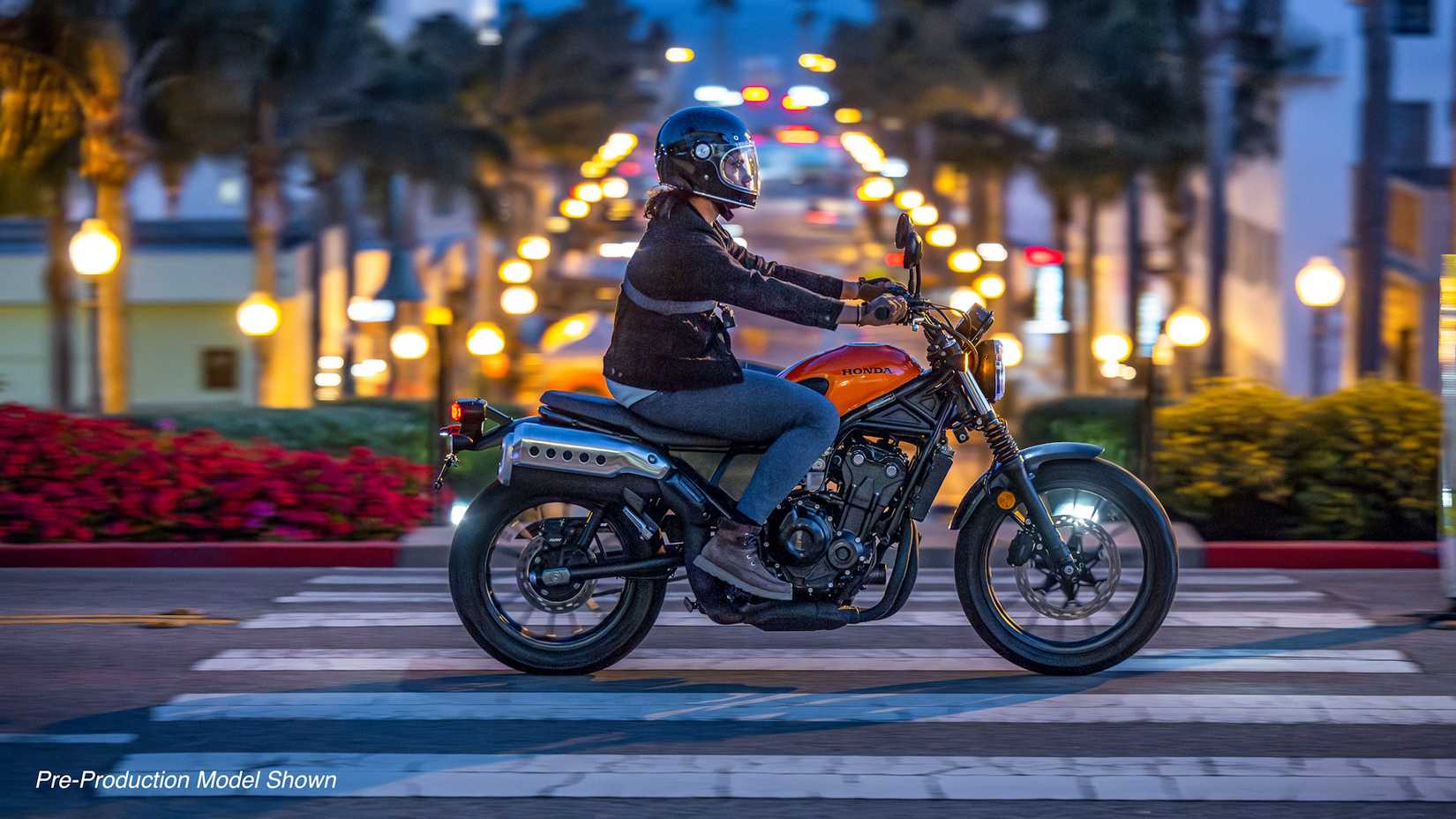Orange 2023 Honda SCL500 cruising through town