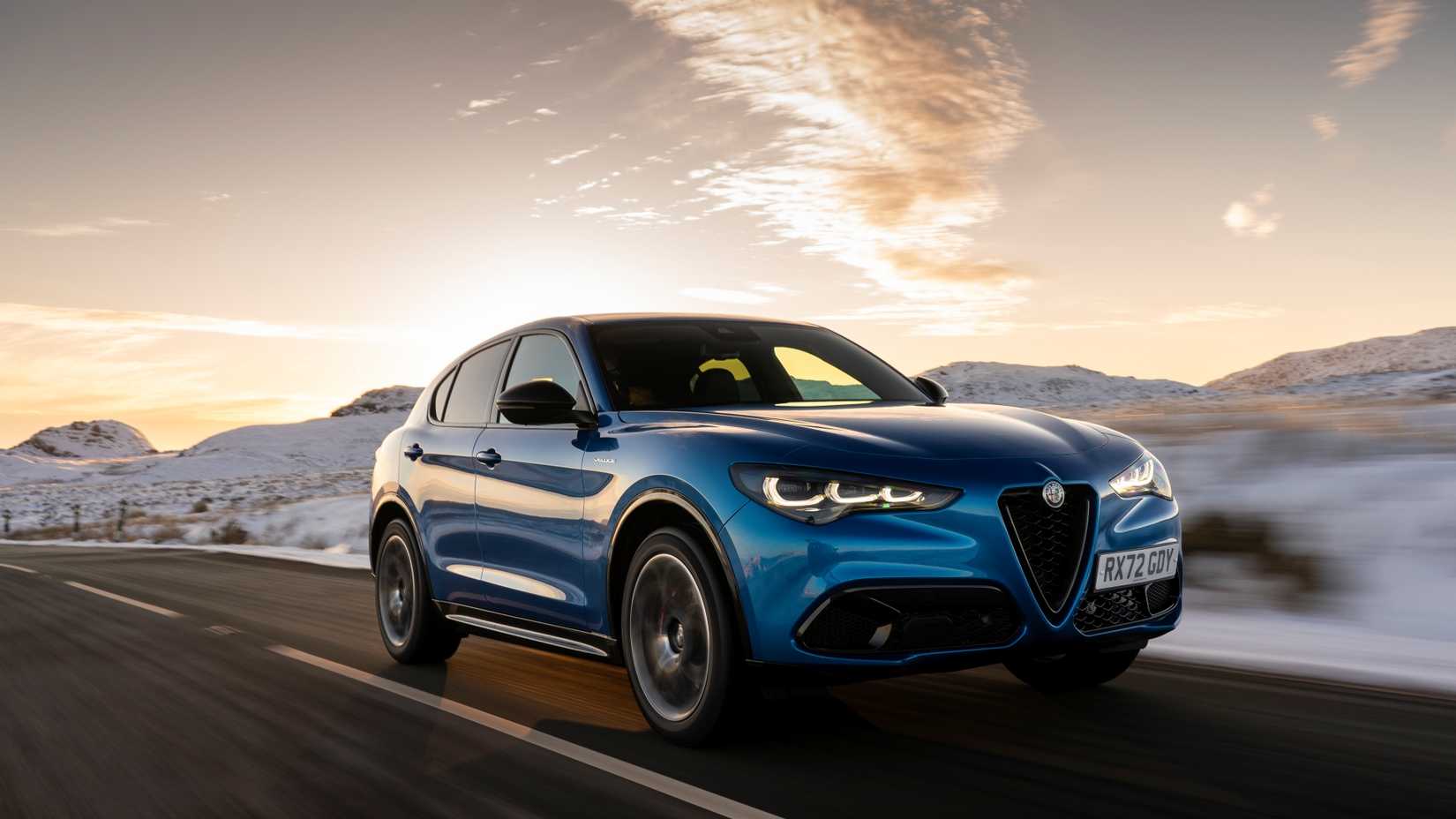 Blue Alfa Romeo Stelvio driving across snow plains