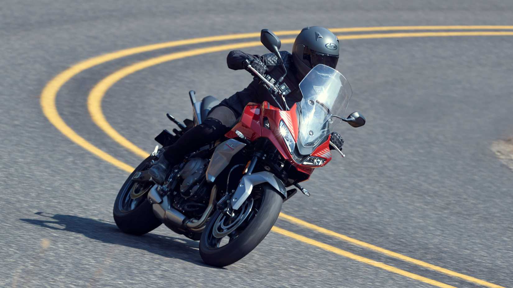 Red 2022 Triumph Tiger Sport 660 coming out of a curve