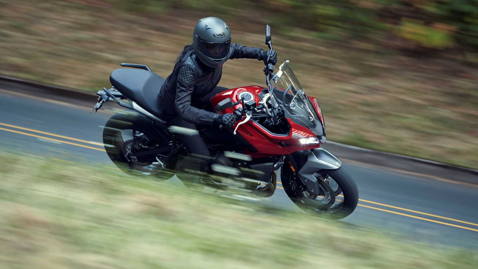 Red Tiger Sport 660 cruising down a rural road
