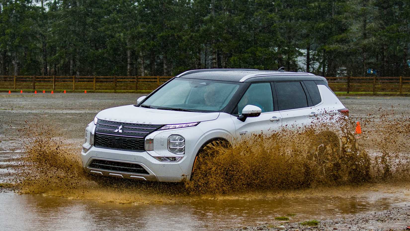 White 2023 Mitsubishi Outlander PHEV driving in mud
