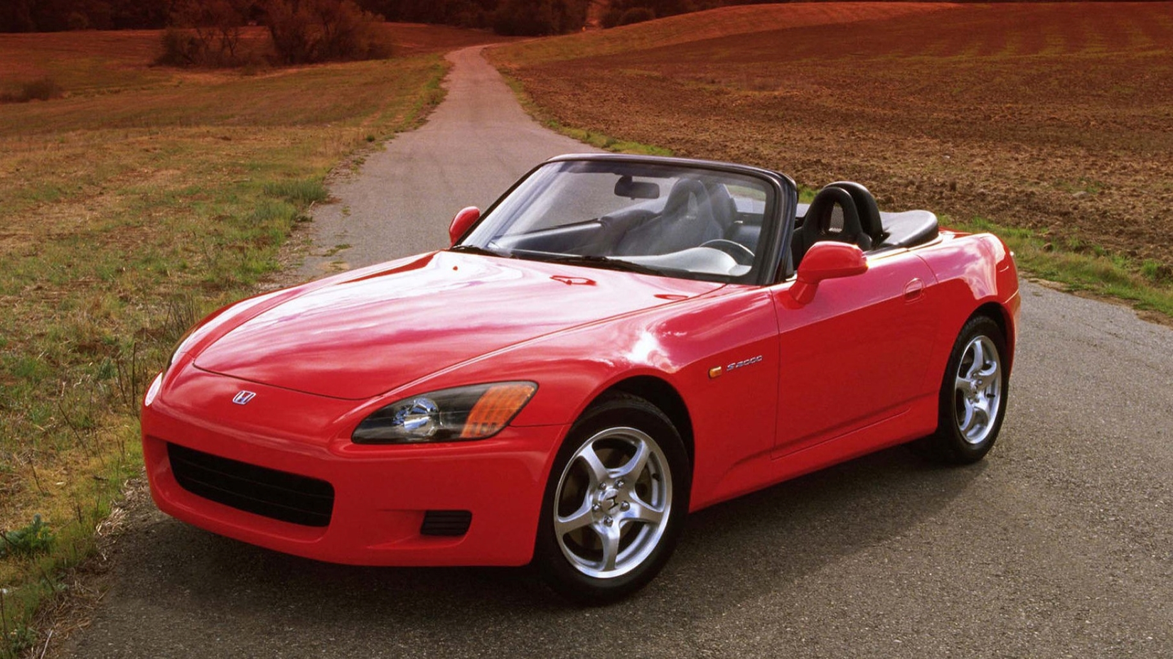2000 Honda S2000 in red posing on country road