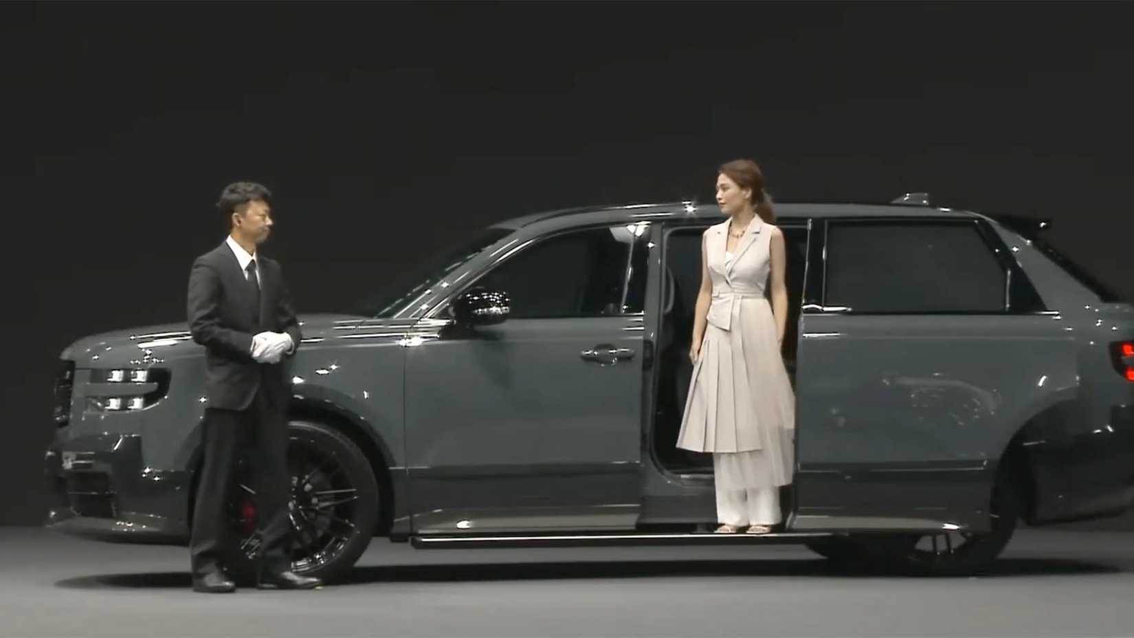 A woman stepping down the Toyota Century SUV GRMN and assisted by the chauffeur
