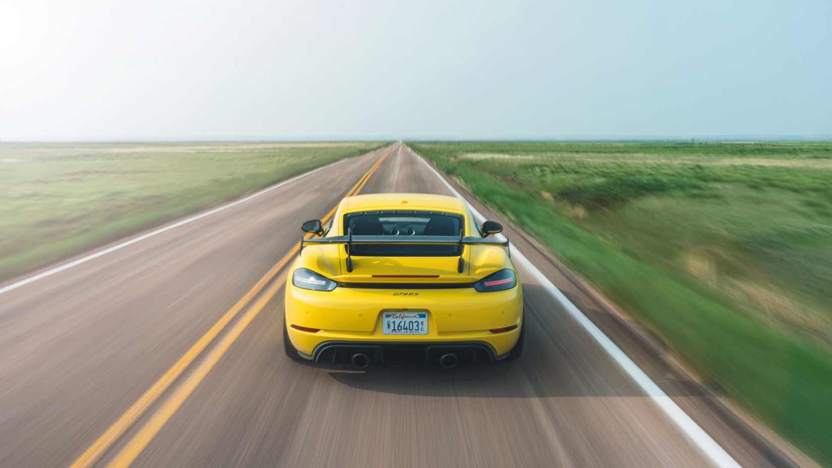 2023 718 Cayman GT4 RS - Racing Yellow - rear - driving on road
