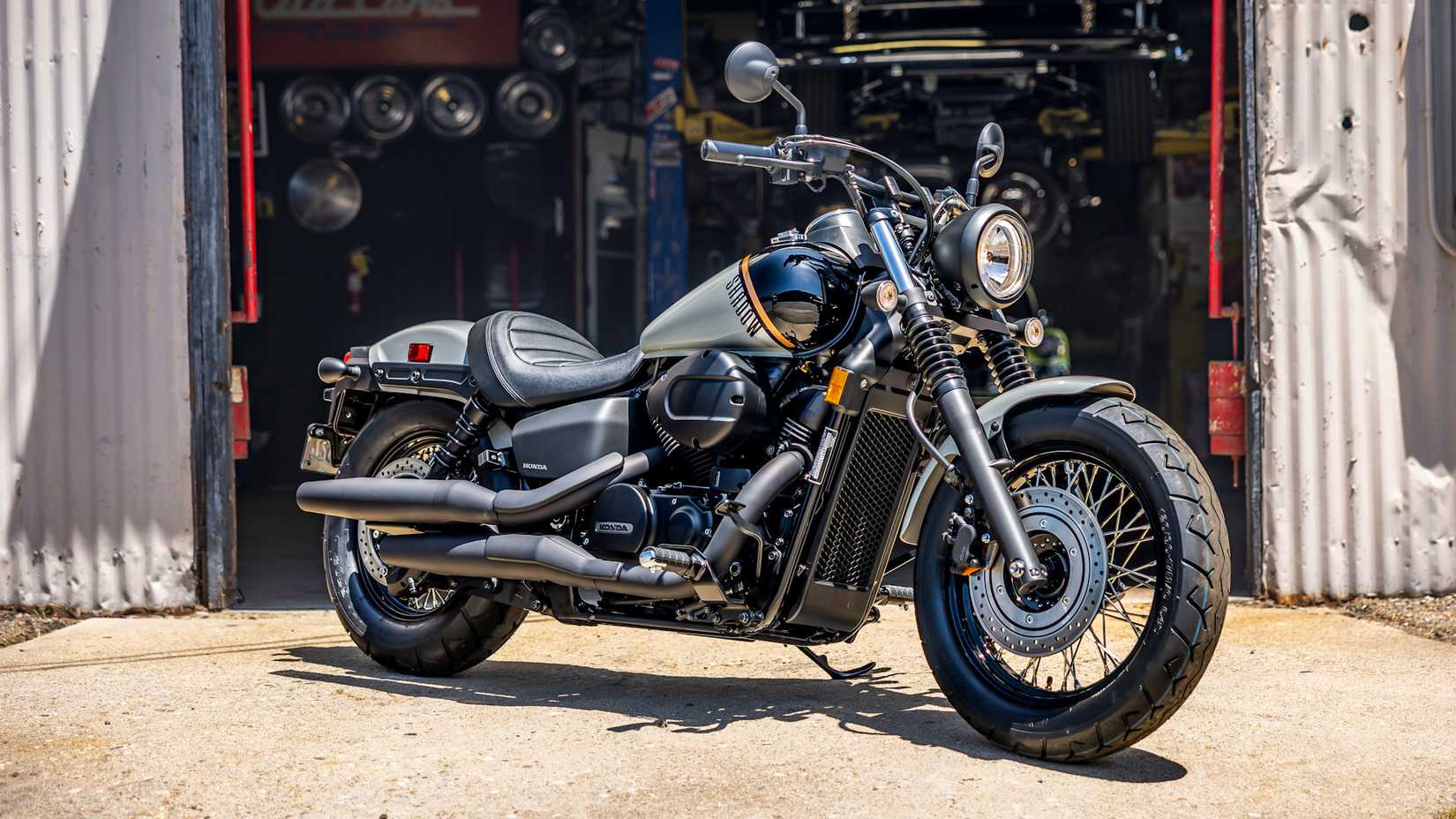 Honda Shadow Phantom estacionado em frente a uma oficina mecânica