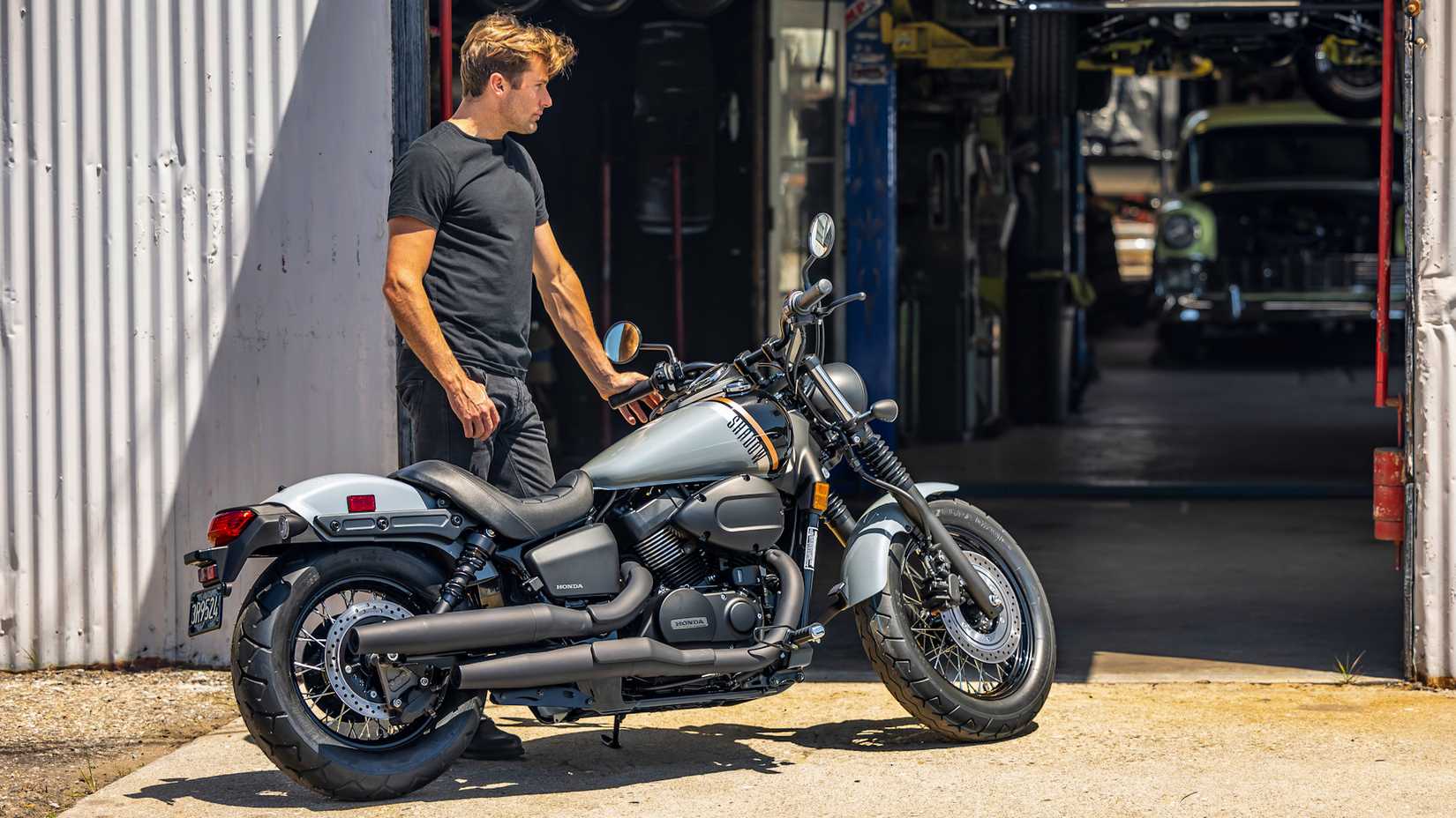 Cara parado ao lado de um Honda Shadow Phantom